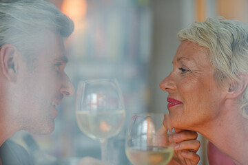 Older romantic couple drinking white wine