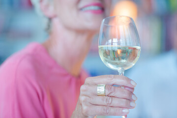 Older woman smelling white wine