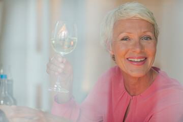 Older woman drinking glass of white wine