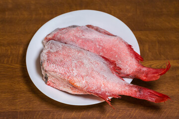 Frozen headless redfish carcasses covered with hoarfrost, top view
