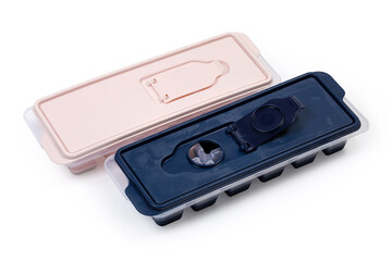 Closed ice cube trays different colors on a white background