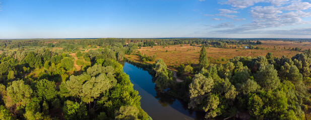 Aerial view of river among the meadows and forests