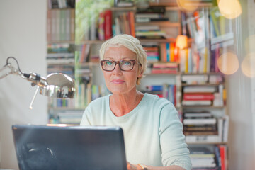 Businesswoman smiling at computer in home office