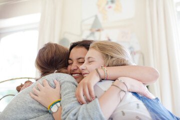 Obraz na płótnie Canvas Three teenage girls embracing in bedroom