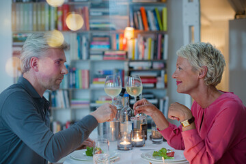 Older couple toasting each other at romantic dinner