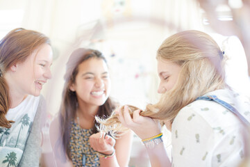 Three teenage girls relaxing in bedroom