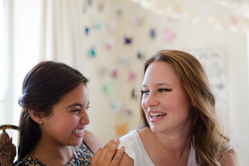 Two teenage girls playing in bedroom