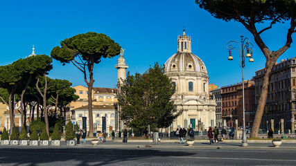 Fototapeta na wymiar The Church of the Most Holy Name of Mary at the Trajan Forum (Santissimo Nome di Maria al Foro Traiano) and Trajan's Column, as seen from dei Fori Imperiali street in Rome, Italy