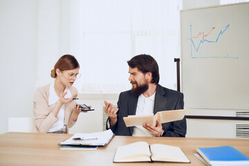 man and woman sitting at a desk office work technology communication