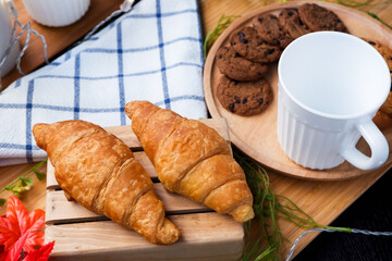 cookie and croissant on wooden tray