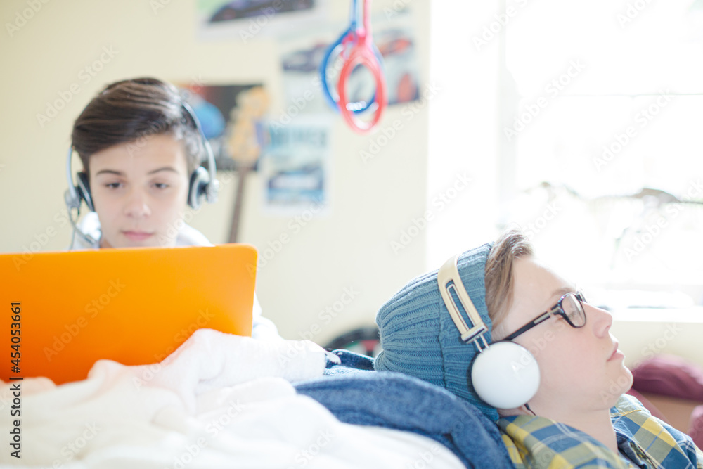 Wall mural Two teenage boys using electronic devices in room