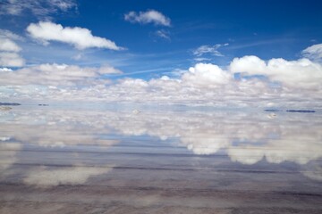 Salar de Uyuni. Salt flat with water. Reflections of a perfect sky. Blue sky and clouds reflection on the water of the salt flat