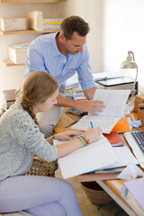 Fototapeta na wymiar Father helping teenage daughter with her homework