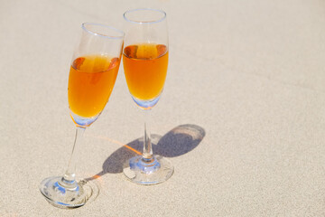Two glasses of champagne on sand beach