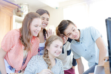 Fototapeta premium Group of teenagers waving while communicating via internet