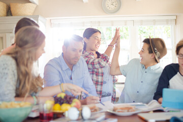 Group of teenagers doing high five in living room