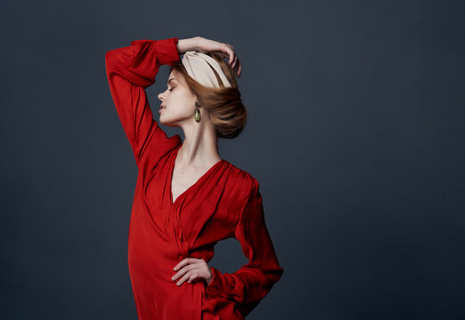 woman in red dress headband posing elegant style dark background