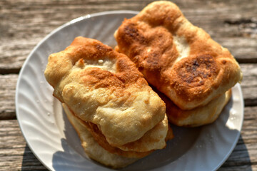 Traditional home made deep fried  patties  covered with sugar  оn rustic backgroud.Mekitsa or Mekica,  on wooden  rustic  background. Made of kneaded dough that is deep fried  .Carnival tortelli stuff