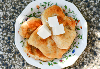 Traditional Bulgarian home made deep fried  patties  covered with sugar  оn rustic backgroud.Mekitsa or Mekica,  on wooden  rustic  background. Made of kneaded dough that is deep fried 