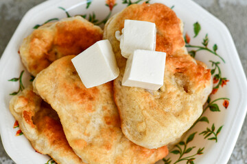 Traditional Bulgarian home made deep fried  patties  covered with sugar  оn rustic backgroud.Mekitsa or Mekica,  on wooden  rustic  background. Made of kneaded dough that is deep fried 