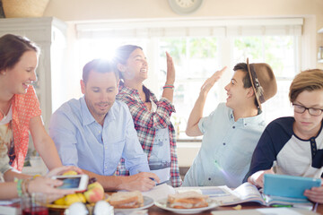 Group of teenagers doing high five in living room