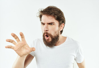emotional man in a white t-shirt irritated facial expression light background