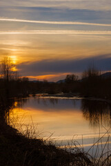 Winter sunset with mist and sky reflection over River Serchio near the city of Lucca
