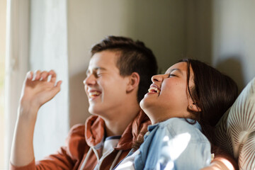 Teenage couple lying in bed and eating popcorn