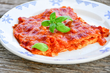   Delicious Home made keto diet  Lasagna bolognese  with  Lupin Flour, minced meat,tomato sauce and spinach  on a wooden rustic  background.Home made low carb italian meal
