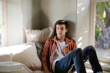 Teenage boy lying on sofa and thinking