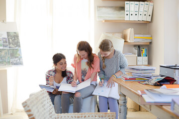 Three teenage girls doing homework in room