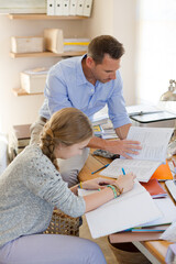 Father helping teenage daughter with her homework