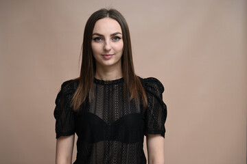 Portrait of a young brunette girl on a beige background