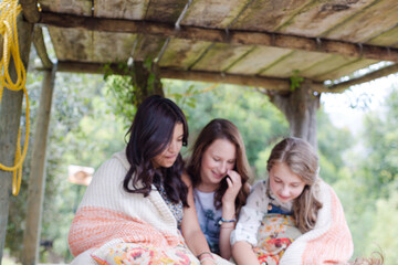 Three teenage girls playing in tree house in summer