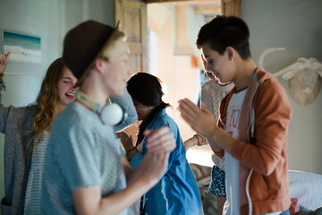 Group of teenagers dancing in living room
