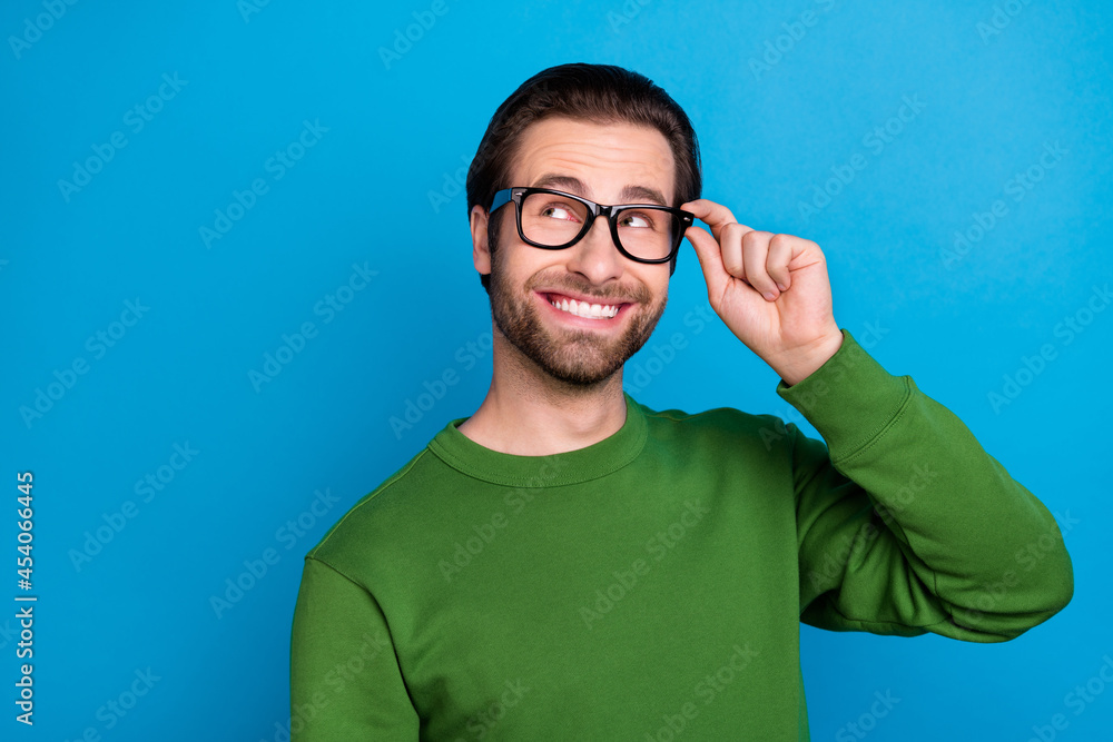 Poster photo of young smiling dreamy man look copyspace wear glasses thinking brainstorming isolated on blu