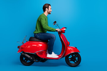 Fototapeta premium Full size profile side photo of smiling good mood man ride red moped travel freedom isolated on blue color background