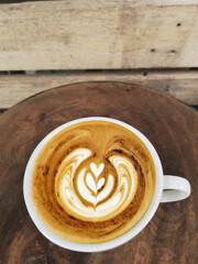 a cup of latte art coffee on wooden background                                                                                                                                                          