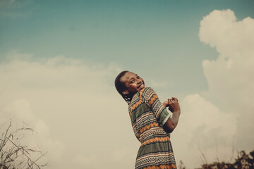 Smiling woman in patterned dress against sky