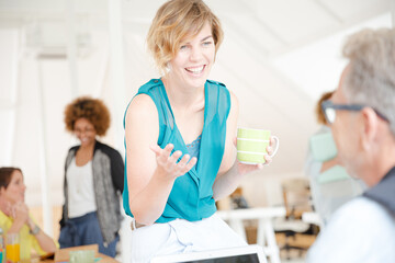 Fototapeta premium Man and woman sitting in office,smiling and talking