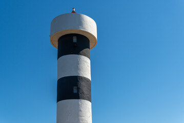 Close-up of the lighthouse of Colonia de Sant Jordi town on the island of Mallorca with the blue...