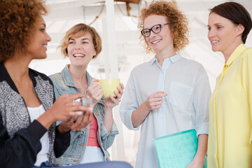 Women with coffe cup smiling in office
