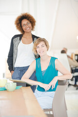 Fototapeta premium Women using digital tablet and smiling in office