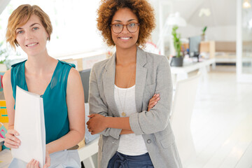 Fototapeta premium Women smiling in office, holding documents