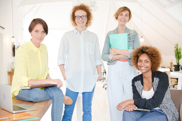 Obraz premium Portrait of women smiling in office with laptop on desk