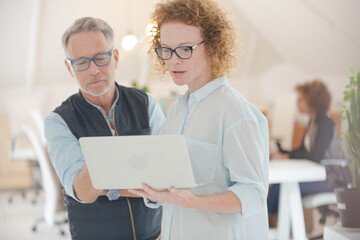 Fototapeta premium Portrait of man and woman with laptop, smiling in office