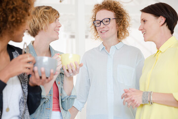 Women with coffe cup smiling in office