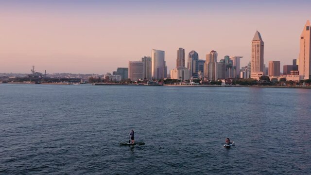 Aerial: Paddleboarding and San Diego City skyline, California, USA