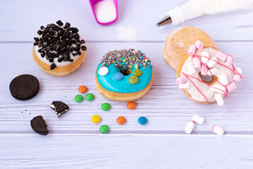 colored donuts with pieces of chocolate icing sugar and background sugar