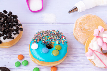 colored donuts with pieces of chocolate icing sugar and background sugar